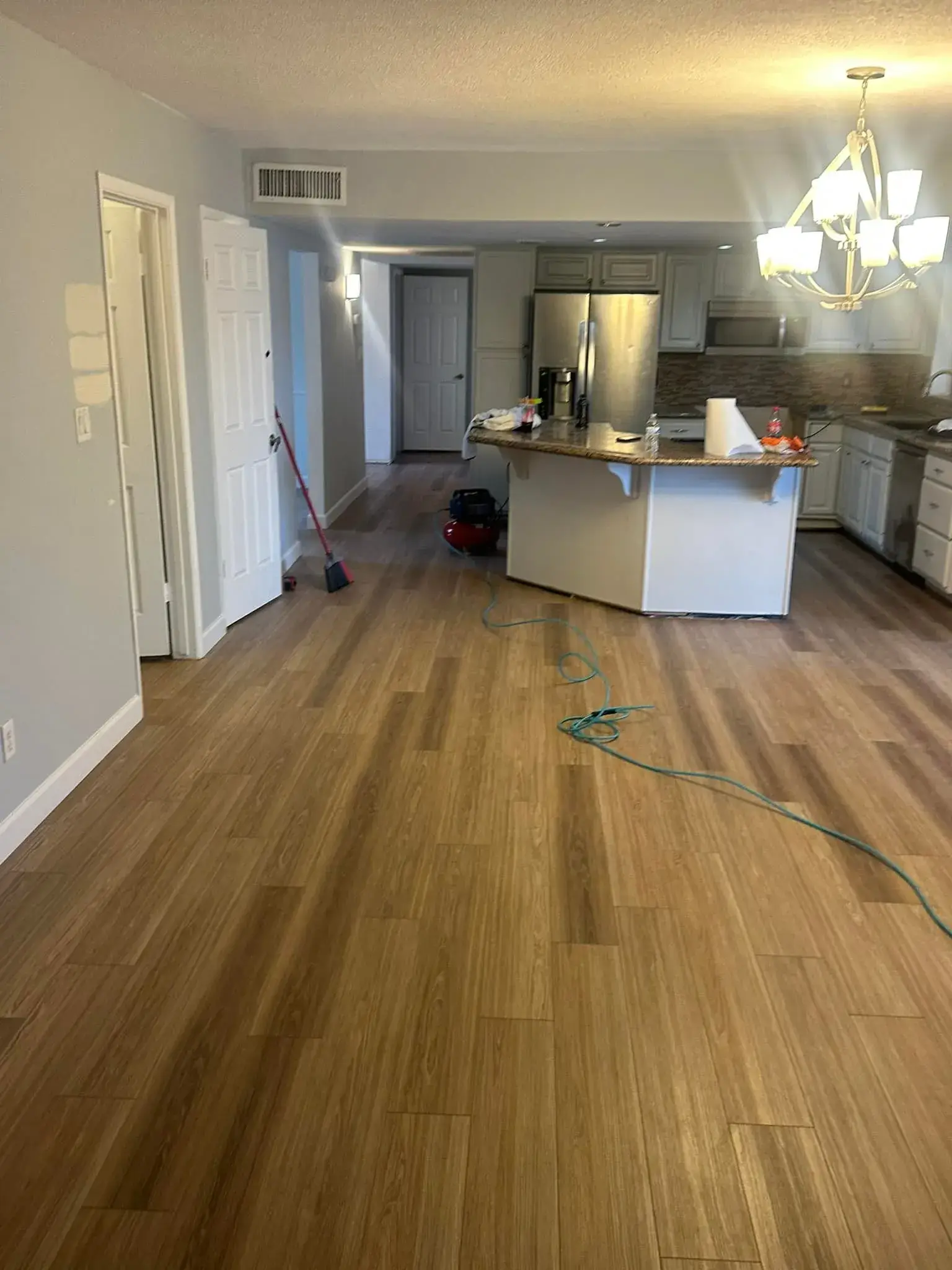 Finished Arizona living room with warm brown wood-look laminate flooring and granite countertops installed by Zona Floors