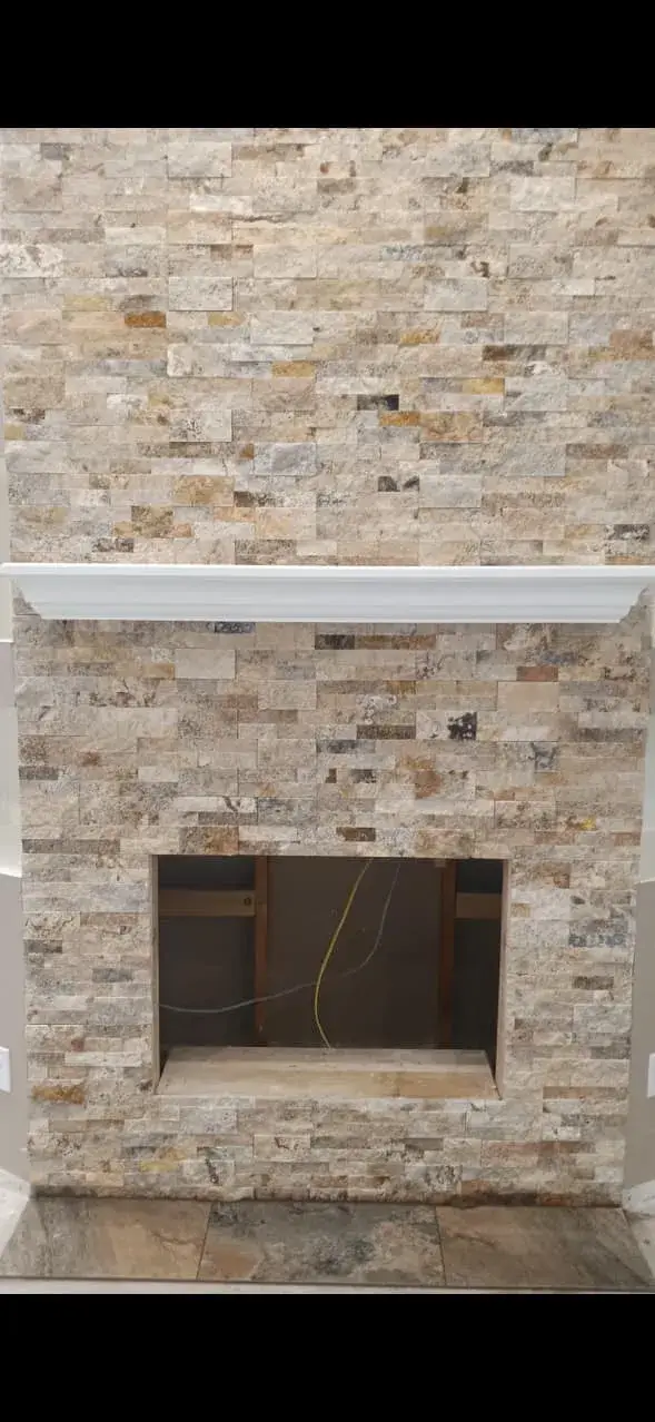 Stacked travertine natural stone fireplace surround with custom mantel installed by Zona Floors in an Arizona home